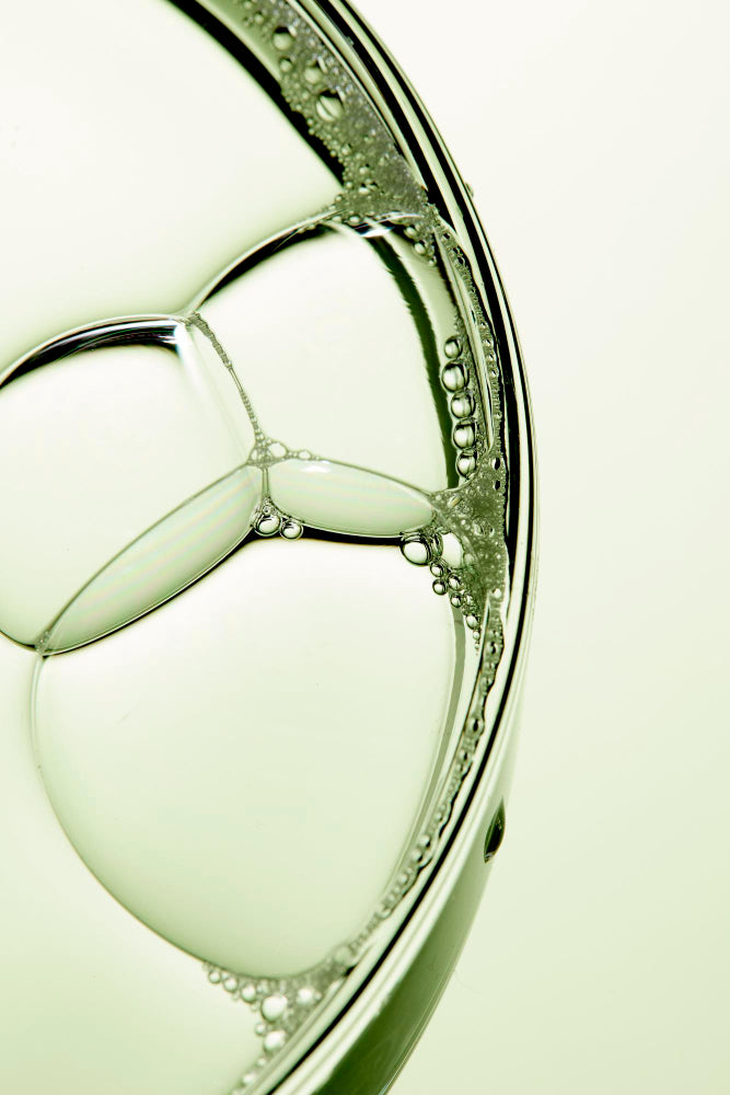 Close-up of a bubble with a light green tint on a light background