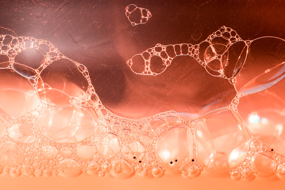 Close-up of soap bubbles on a textured surface with a warm color tone.